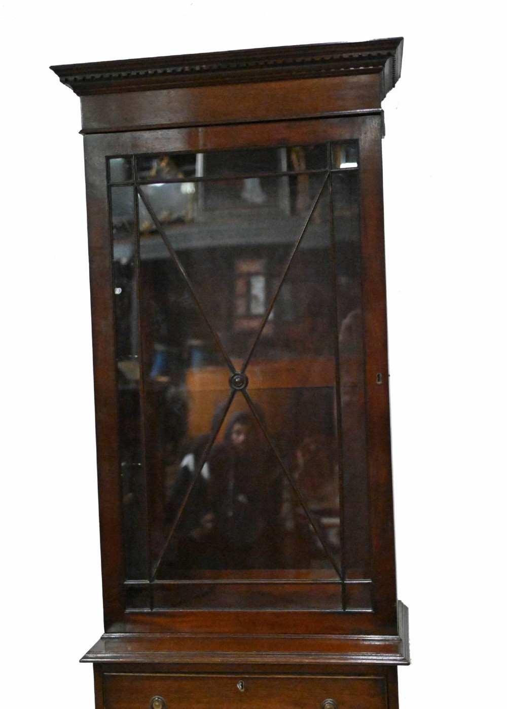 A tall Georgian mahogany glazed bookcase featuring an astragal glass upper cabinet set above four graduated drawers with brass pull knobs. View IV