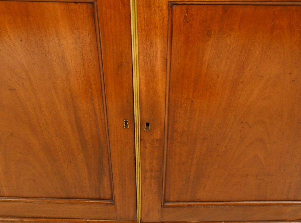 A Georgian mahogany secretaire bookcase featuring a glazed upper cabinet, a pull-out secretaire drawer with brass oval handles, and lower panelled doors. View VII