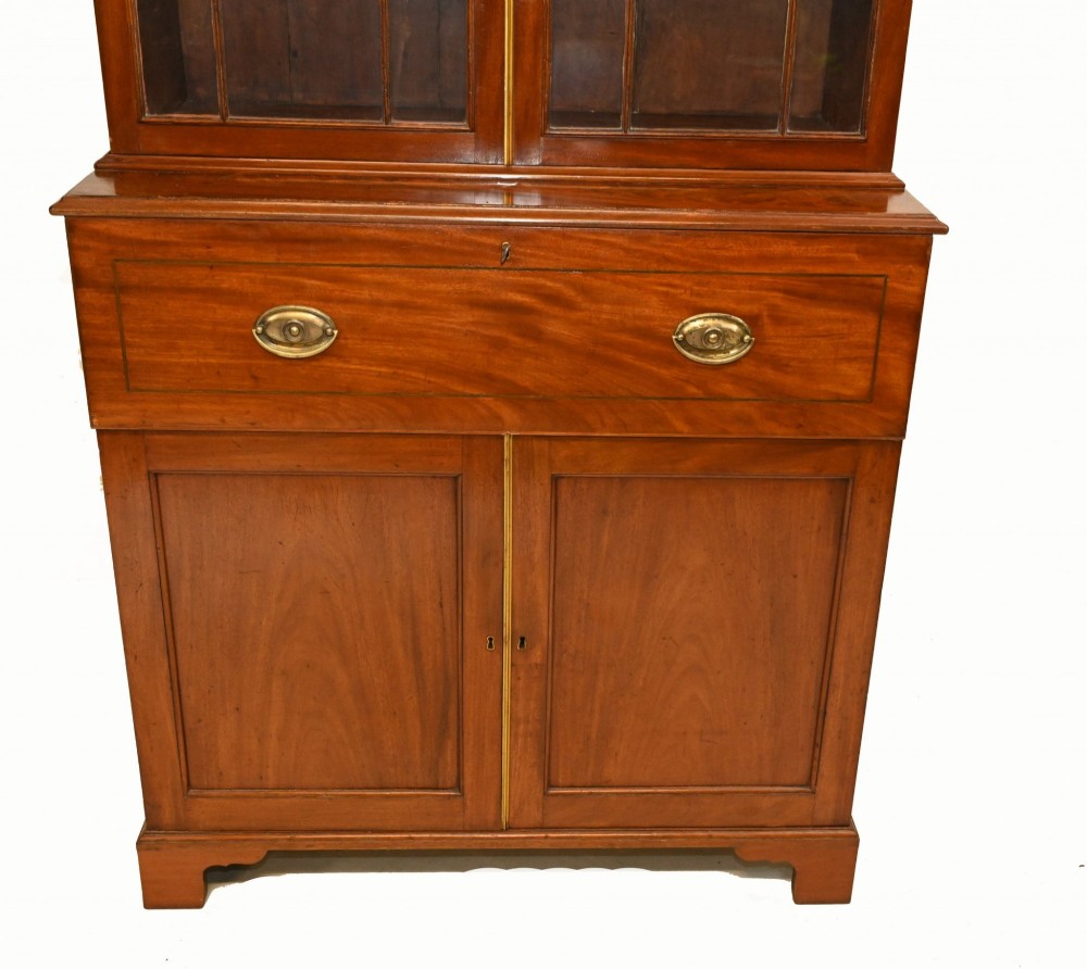 A Georgian mahogany secretaire bookcase featuring a glazed upper cabinet, a pull-out secretaire drawer with brass oval handles, and lower panelled doors. View X