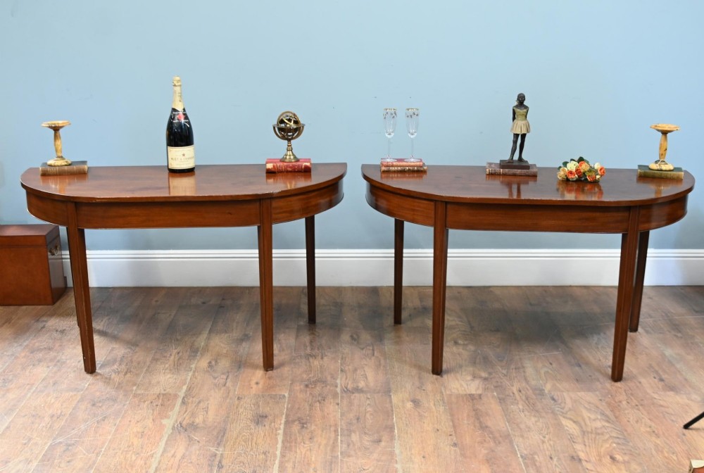 A pair of antique Georgian mahogany demi-lune console tables with semi-circular tops and straight tapered legs. View II