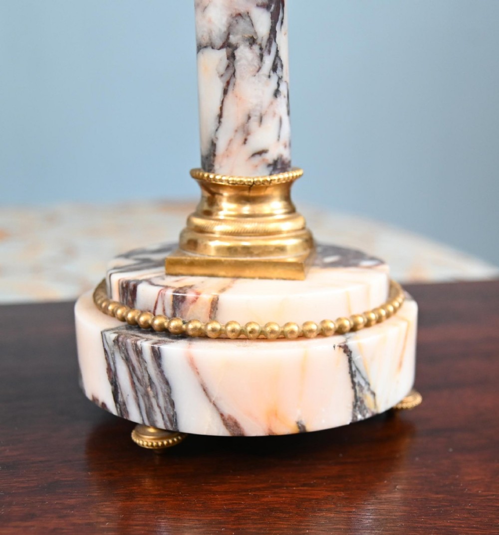 A late nineteenth-century French clock garniture set featuring a central portico clock in purple-veined white marble with gilt bronze mounts, flanked by two matching two-light candelabras. View VI