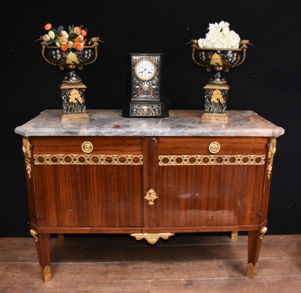 A French Empire style rosewood commode with a grey veined marble top, ornamental gilt bronze mounts, and square tapered legs with brass feet.