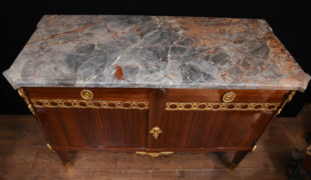 A French Empire style rosewood commode with a grey veined marble top, ornamental gilt bronze mounts, and square tapered legs with brass feet. View II