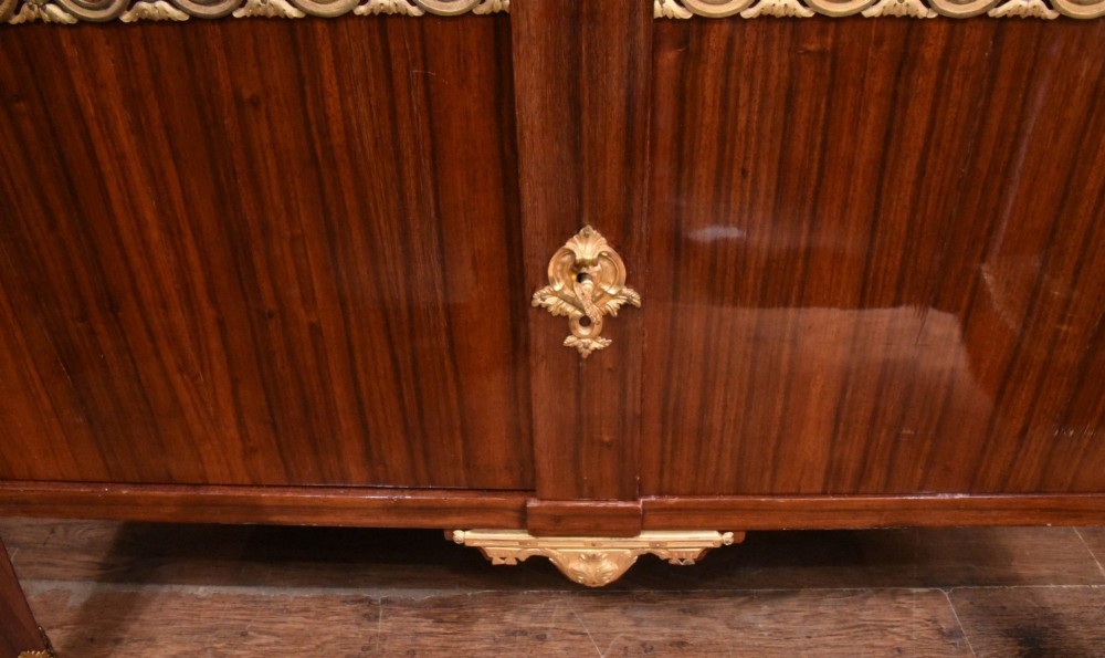 A French Empire style rosewood commode with a grey veined marble top, ornamental gilt bronze mounts, and square tapered legs with brass feet. View VIII