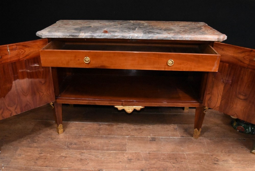 A French Empire style rosewood commode with a grey veined marble top, ornamental gilt bronze mounts, and square tapered legs with brass feet. View XIV