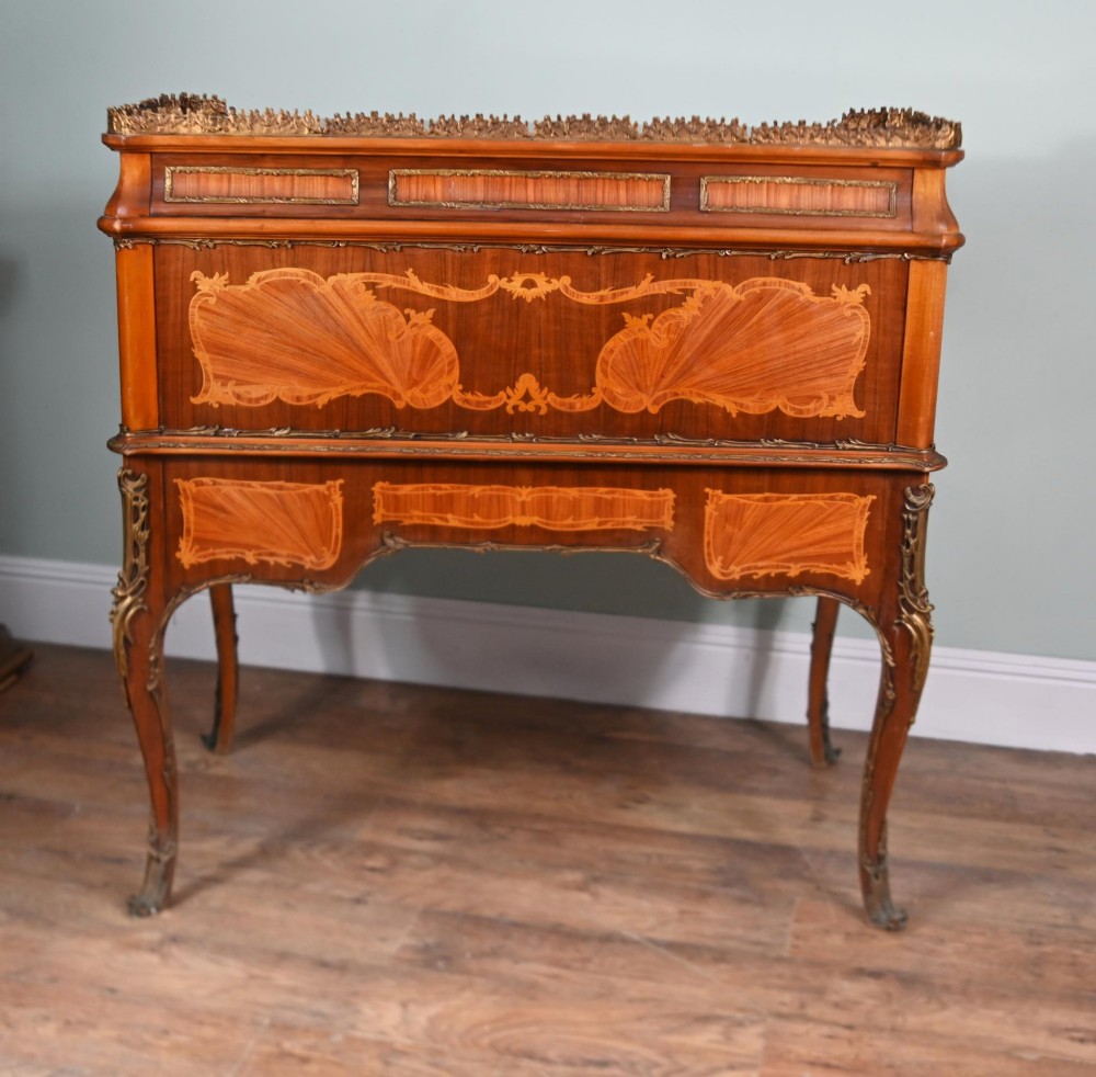 An antique French roll-top bureau featuring wood marquetry inlay, decorative brass mounts, cabriole legs, and drawers. View II