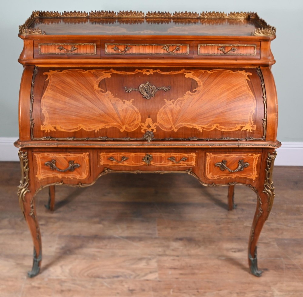 An antique French roll-top bureau featuring wood marquetry inlay, decorative brass mounts, cabriole legs, and drawers. View VIII