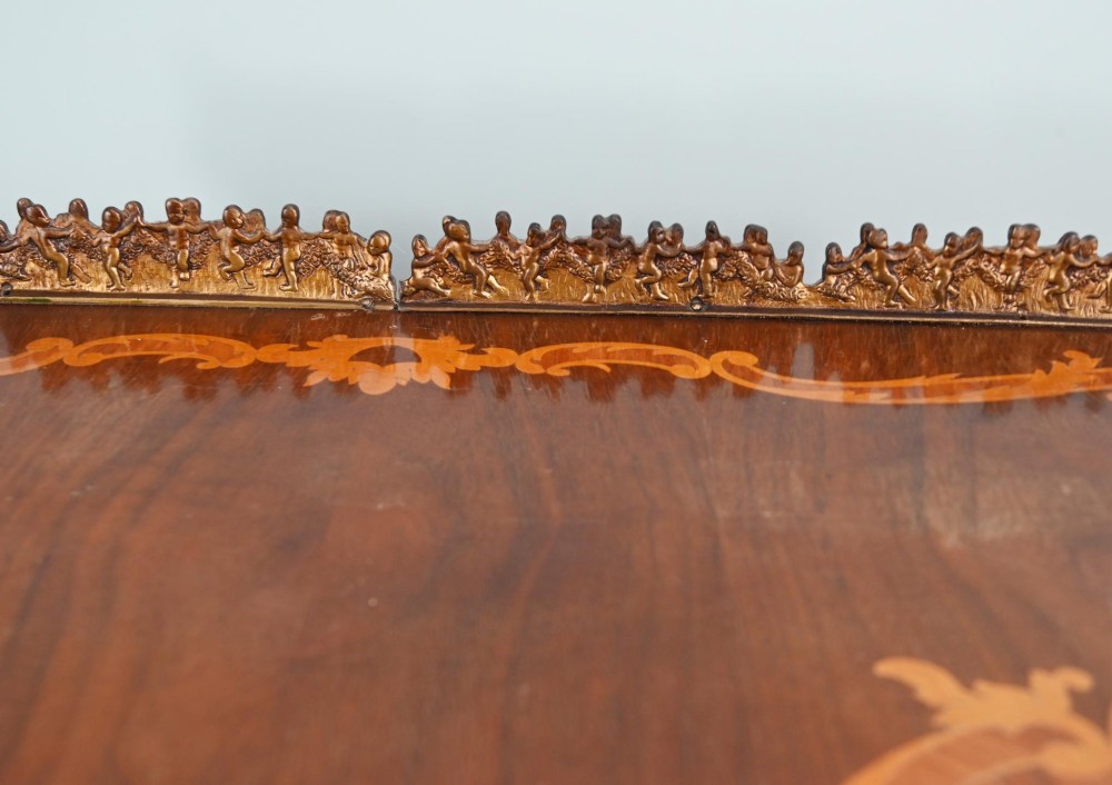 An antique French roll-top bureau featuring wood marquetry inlay, decorative brass mounts, cabriole legs, and drawers. View IX
