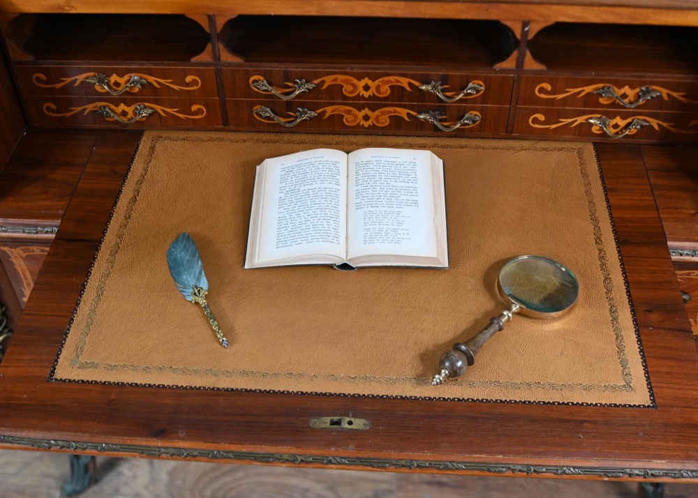 An antique French roll-top bureau featuring wood marquetry inlay, decorative brass mounts, cabriole legs, and drawers. View XIII