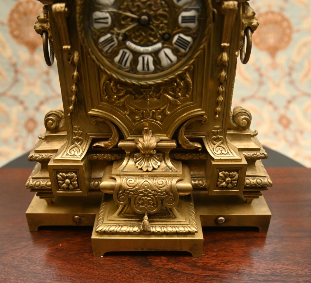 A 19th-century Louis XVI style gilt bronze clock garniture set comprising a central ornate mantel clock flanked by two matching five-light candelabras. View XI