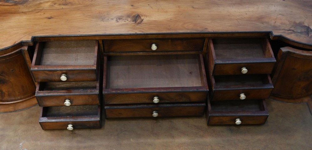 A Regency Revival mahogany ladies writing desk featuring a leather-lined writing surface, elevated drawer superstructure, turned reeded legs, and a curved stretcher. View IV