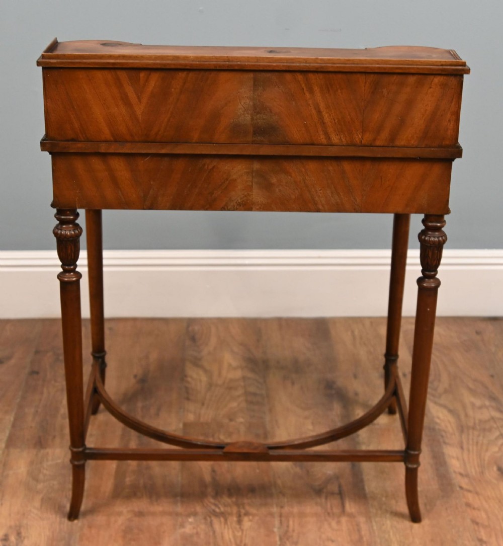 A Regency Revival mahogany ladies writing desk featuring a leather-lined writing surface, elevated drawer superstructure, turned reeded legs, and a curved stretcher. View VI