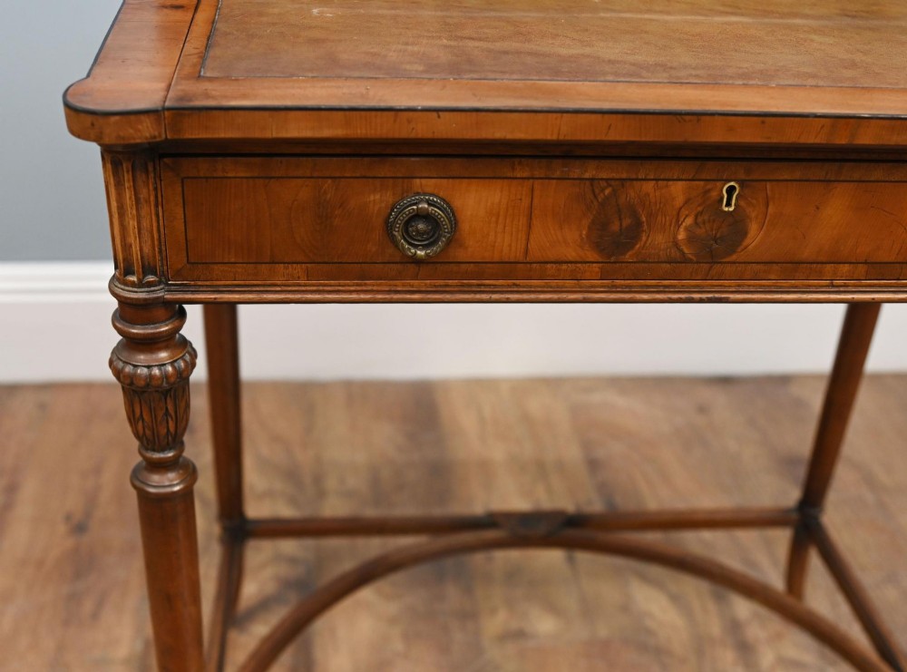 A Regency Revival mahogany ladies writing desk featuring a leather-lined writing surface, elevated drawer superstructure, turned reeded legs, and a curved stretcher. View X