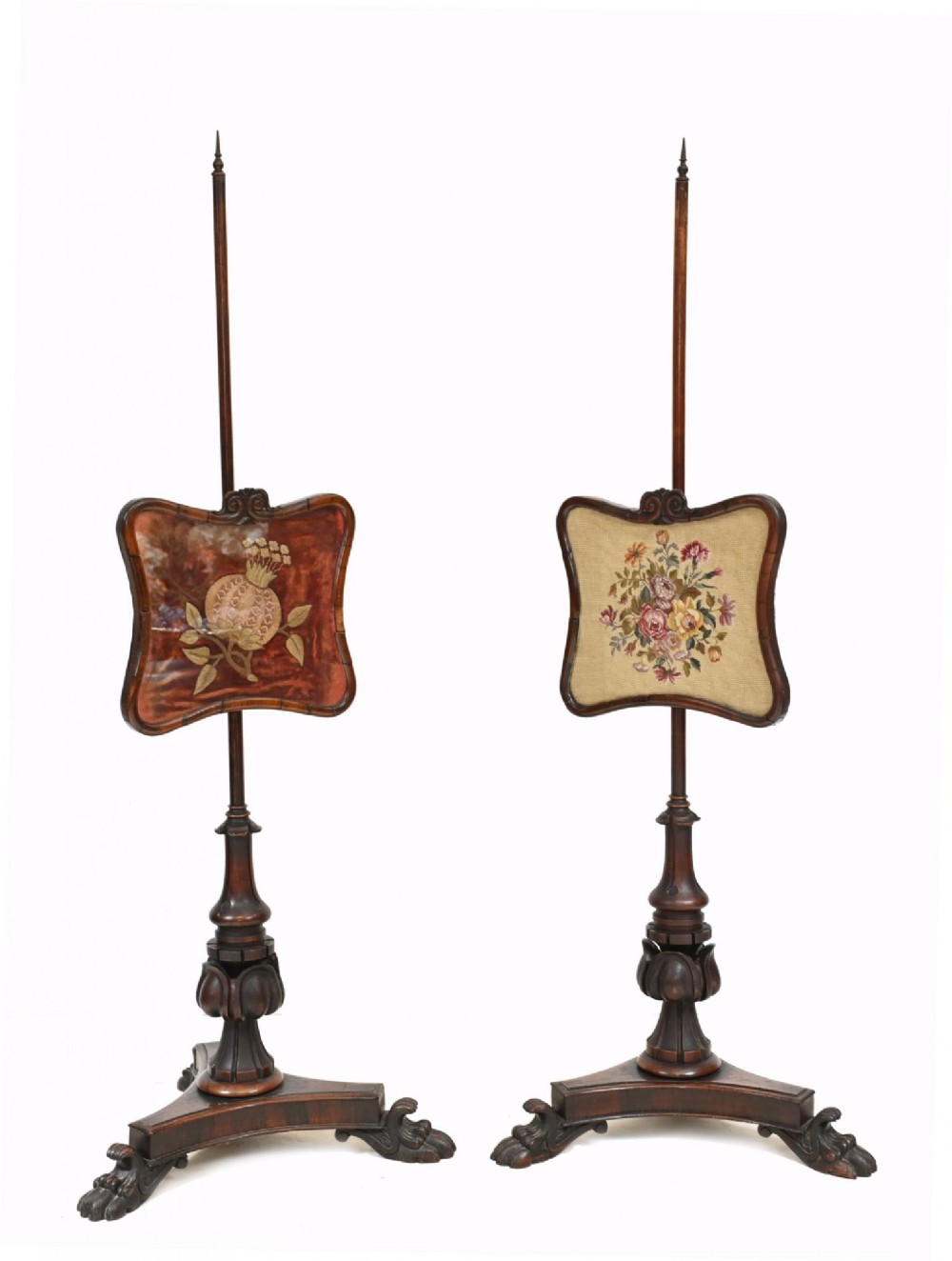 A pair of 19th-century Regency pole screens crafted from dark rosewood with carved tripod bases and adjustable rectangular needlepoint tapestry panels.