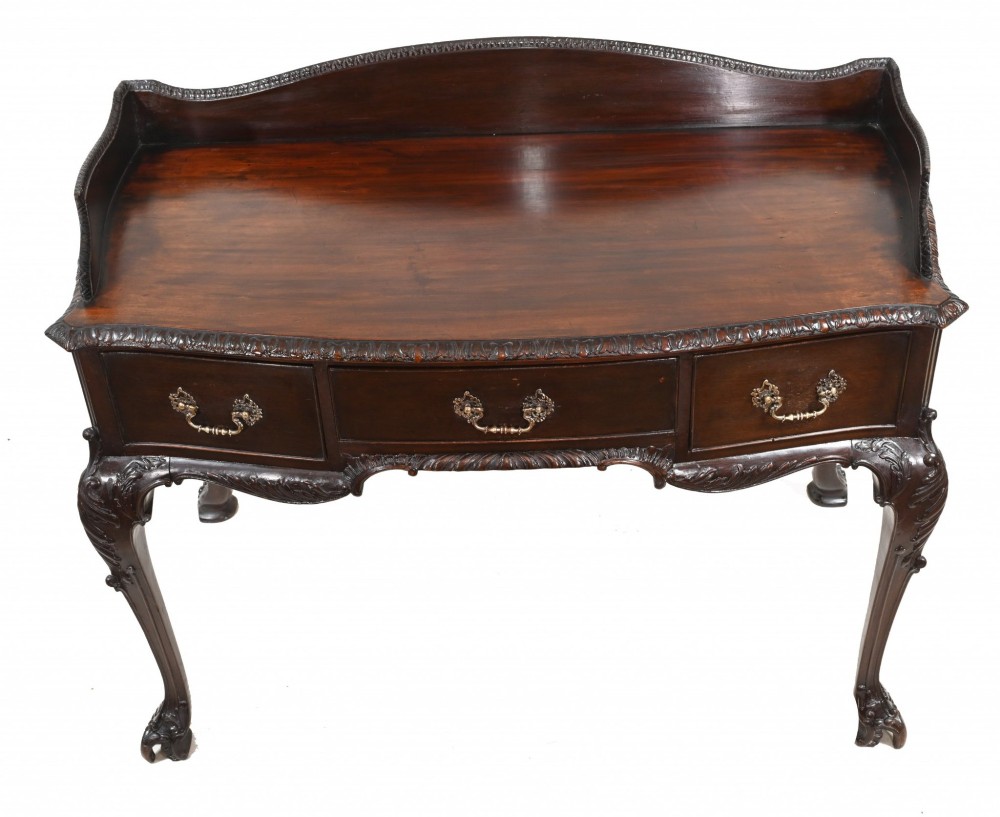 A dark mahogany Victorian console table featuring three drawers with decorative brass handles, carved cabriole legs, and a low gallery back. View V