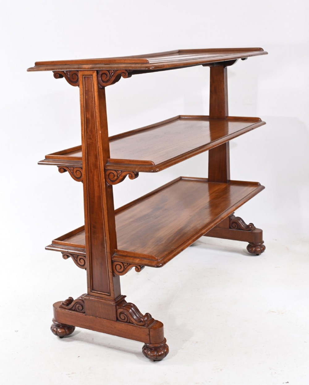 A Victorian mahogany three-tiered dumb waiter buffet with moulded shelf edges and carved scroll feet. View IV