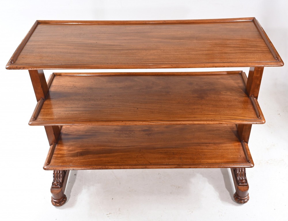 A Victorian mahogany three-tiered dumb waiter buffet with moulded shelf edges and carved scroll feet. View V
