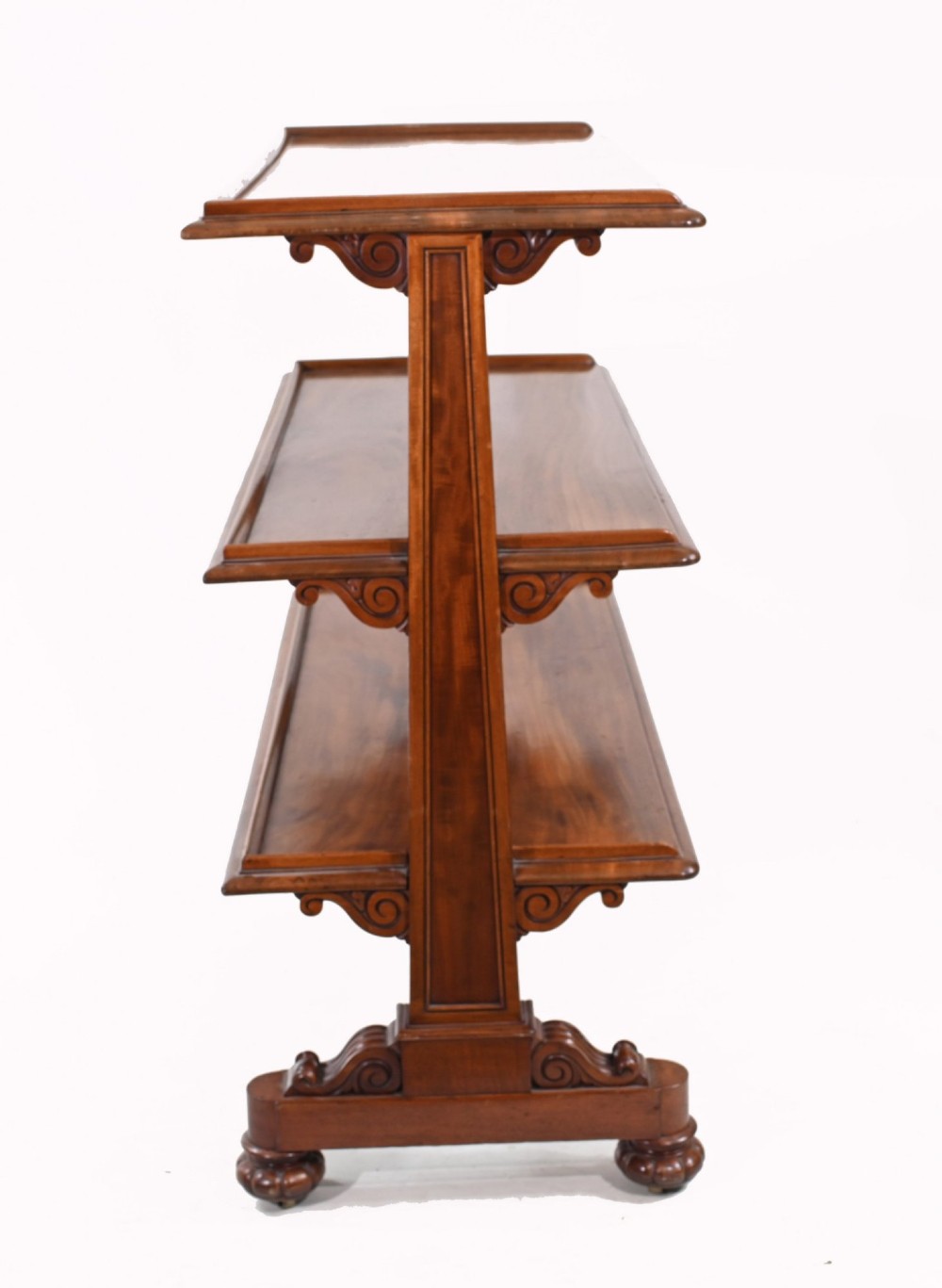 A Victorian mahogany three-tiered dumb waiter buffet with moulded shelf edges and carved scroll feet. View VI