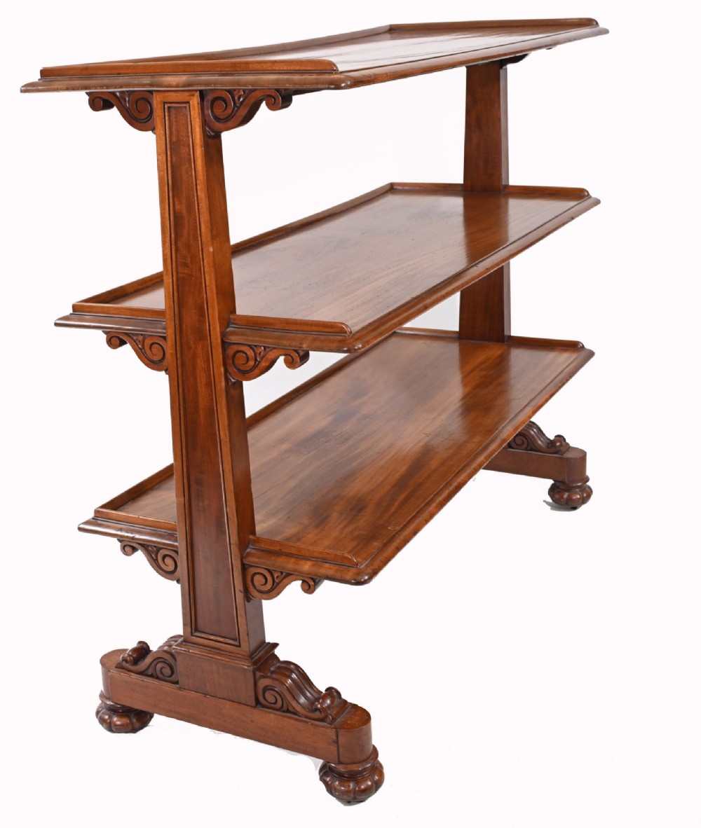 A Victorian mahogany three-tiered dumb waiter buffet with moulded shelf edges and carved scroll feet. View VIII