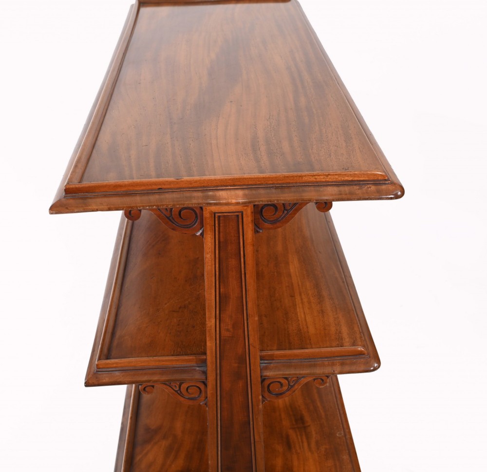 A Victorian mahogany three-tiered dumb waiter buffet with moulded shelf edges and carved scroll feet. View IX
