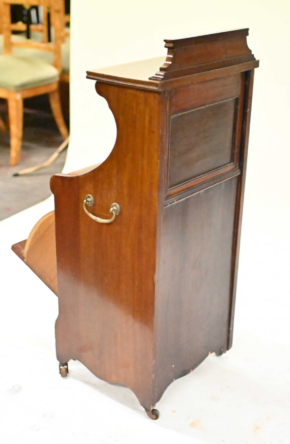 A late Victorian mahogany coal purdonium cabinet featuring satinwood marquetry inlay, a brass handle on the drop-front door, an upper shelf, and a small mirrored back panel. View V