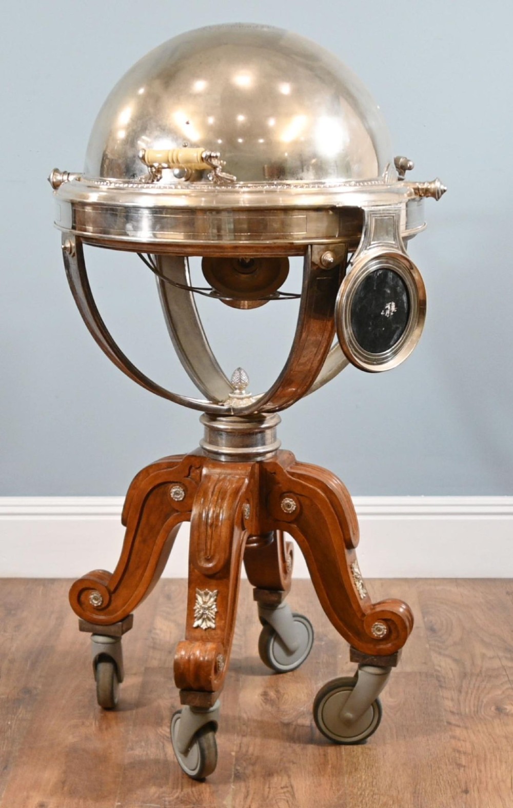 A Victorian silver-plated carvery trolley with a domed retractable cover set atop a carved mahogany pedestal base with swivel castors.