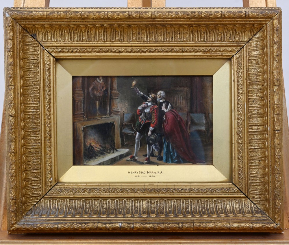A 19th-century Victorian oil painting depicting figures in historical dress examining a portrait by candlelight, set within a heavily carved gold gilt frame. View VI