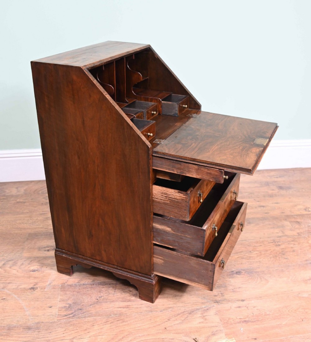 A late Victorian walnut slant-front bureau desk with four drawers and brass teardrop handles. View II