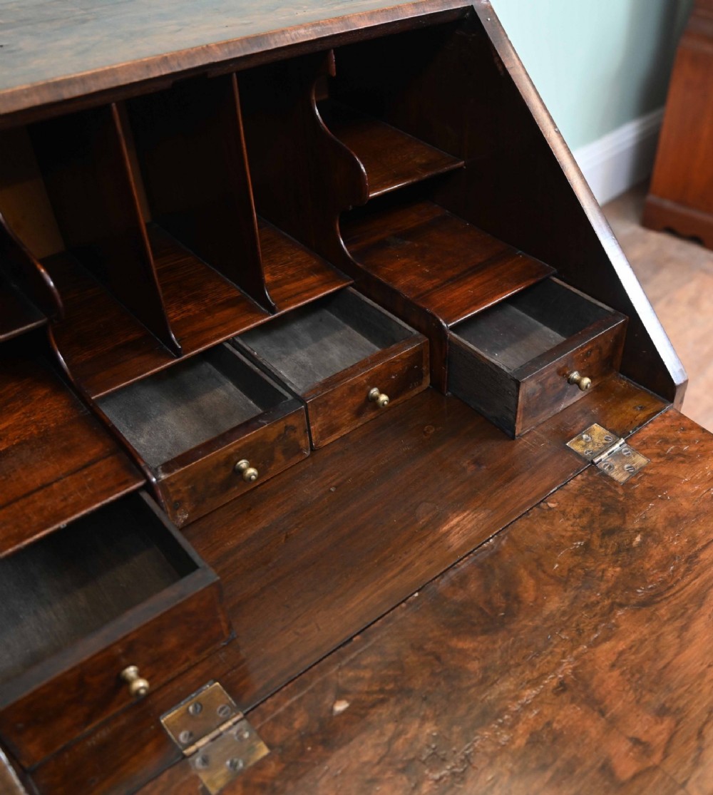 A late Victorian walnut slant-front bureau desk with four drawers and brass teardrop handles. View IV