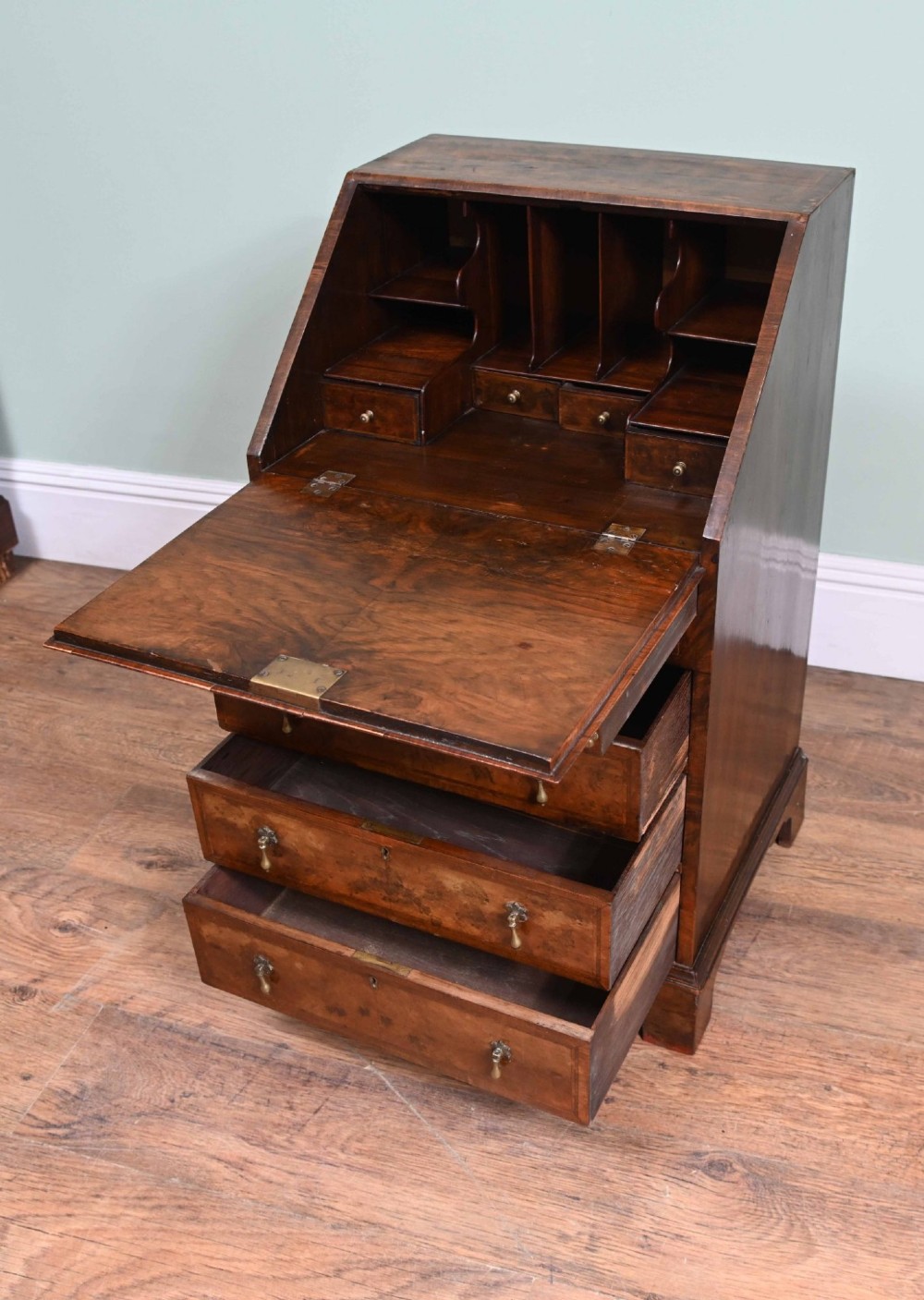 A late Victorian walnut slant-front bureau desk with four drawers and brass teardrop handles. View VII