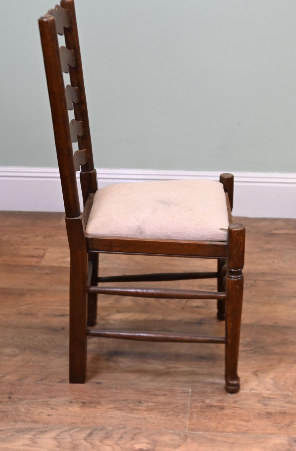 A set of four Edwardian oak ladderback dining chairs featuring two armchairs and two side chairs with turned legs and cream fabric seats. View III