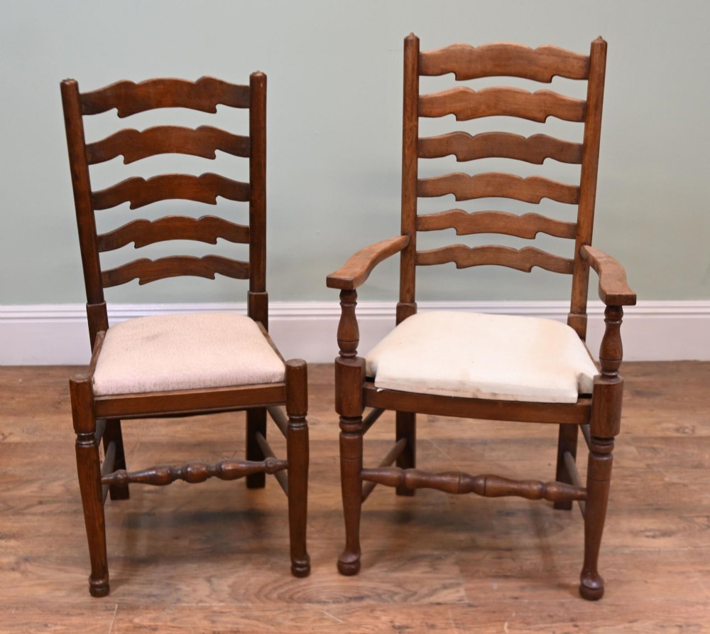 A set of four Edwardian oak ladderback dining chairs featuring two armchairs and two side chairs with turned legs and cream fabric seats. View VII