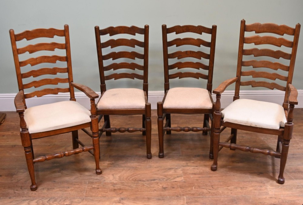 A set of four Edwardian oak ladderback dining chairs featuring two armchairs and two side chairs with turned legs and cream fabric seats. View VIII