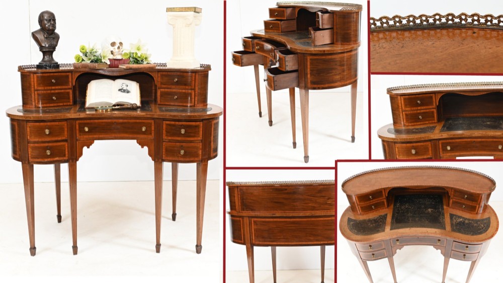 An Edwardian inlaid mahogany kidney-shaped writing desk featuring a raised superstructure with drawers, a central alcove, a leather writing surface, and tapered square legs. View VI