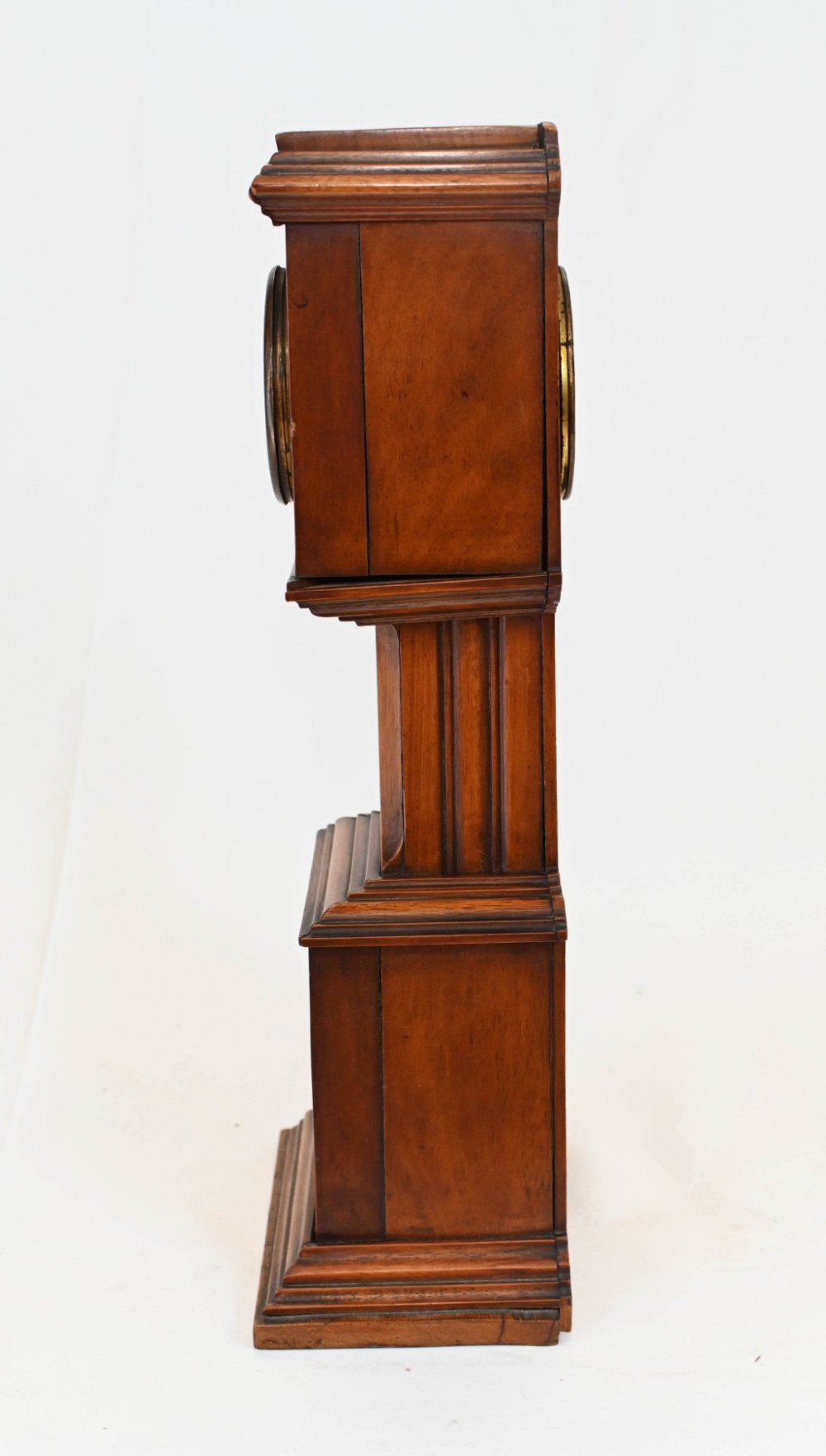 A miniature mahogany longcase clock featuring classical Sheraton style wood inlay with an urn motif and a circular white dial with Roman numerals. View V