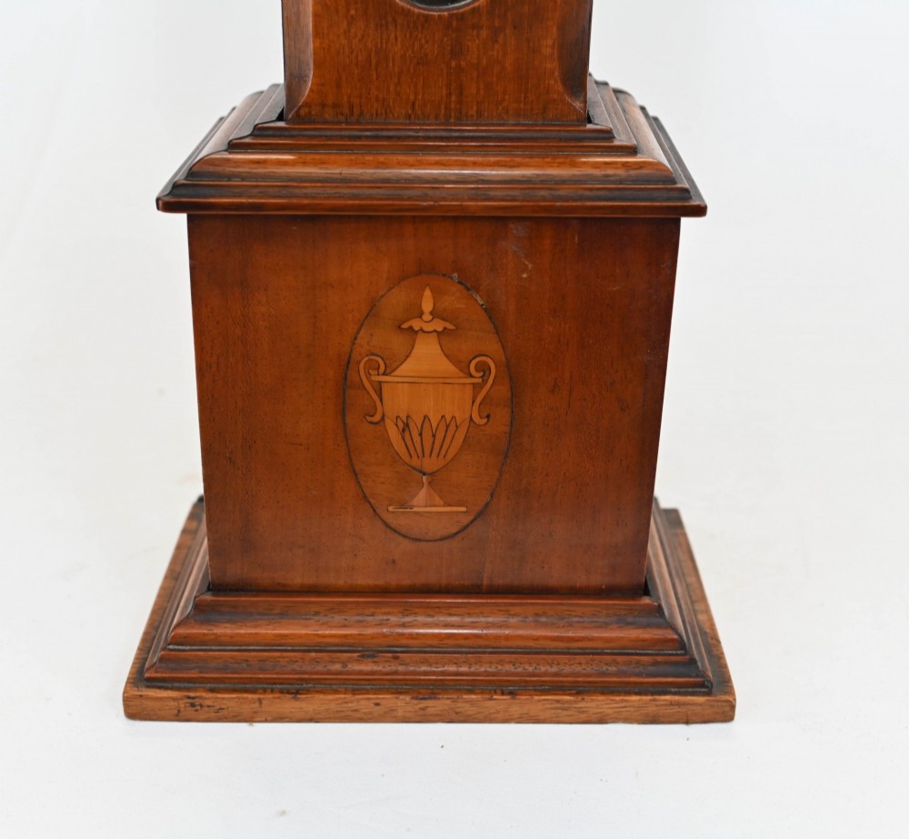 A miniature mahogany longcase clock featuring classical Sheraton style wood inlay with an urn motif and a circular white dial with Roman numerals. View VIII