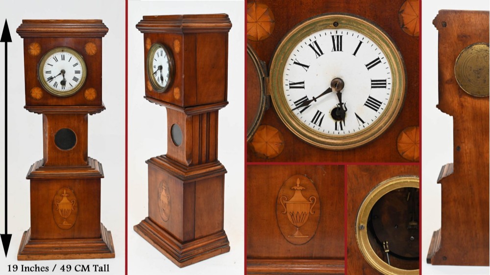 A miniature mahogany longcase clock featuring classical Sheraton style wood inlay with an urn motif and a circular white dial with Roman numerals. View XI