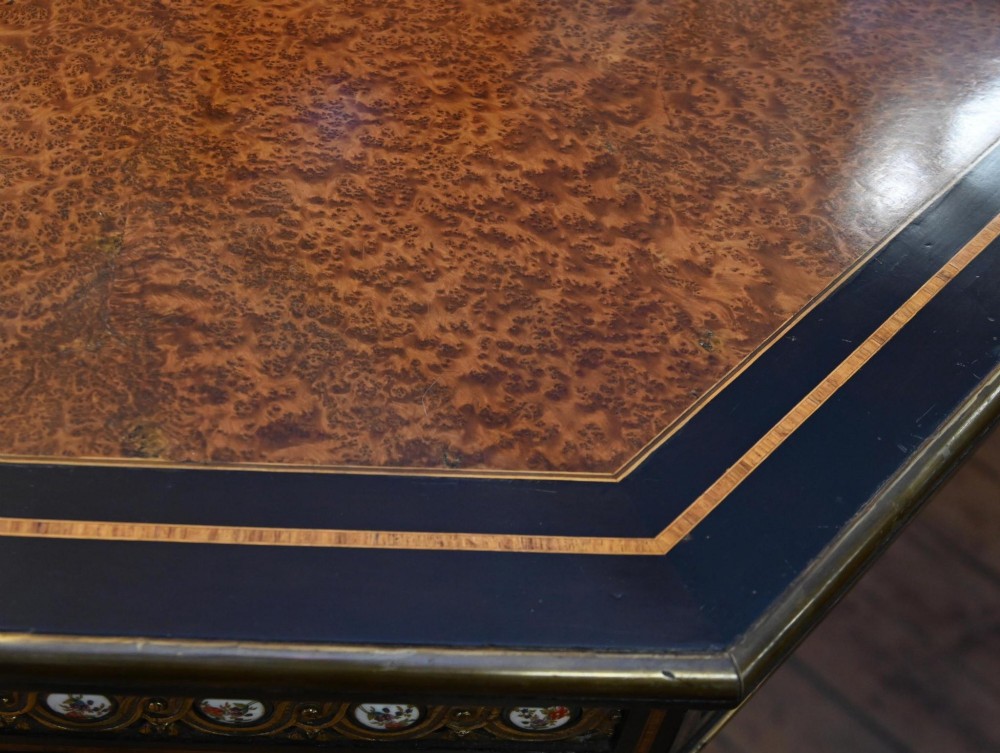 An octagonal Victorian centre table crafted from burr amboyna wood with ebonised borders and an apron decorated with porcelain roundels. View IV