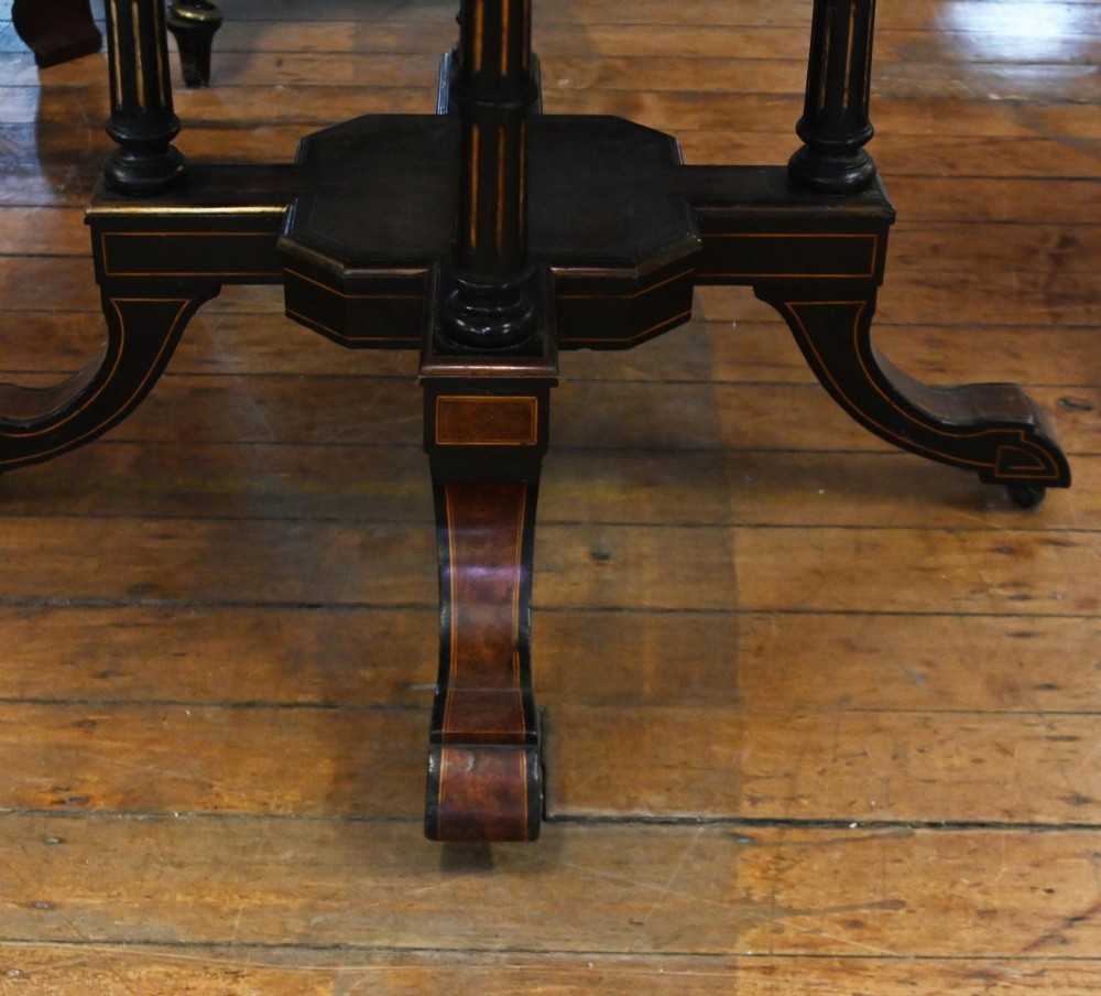 An octagonal Victorian centre table crafted from burr amboyna wood with ebonised borders and an apron decorated with porcelain roundels. View VI