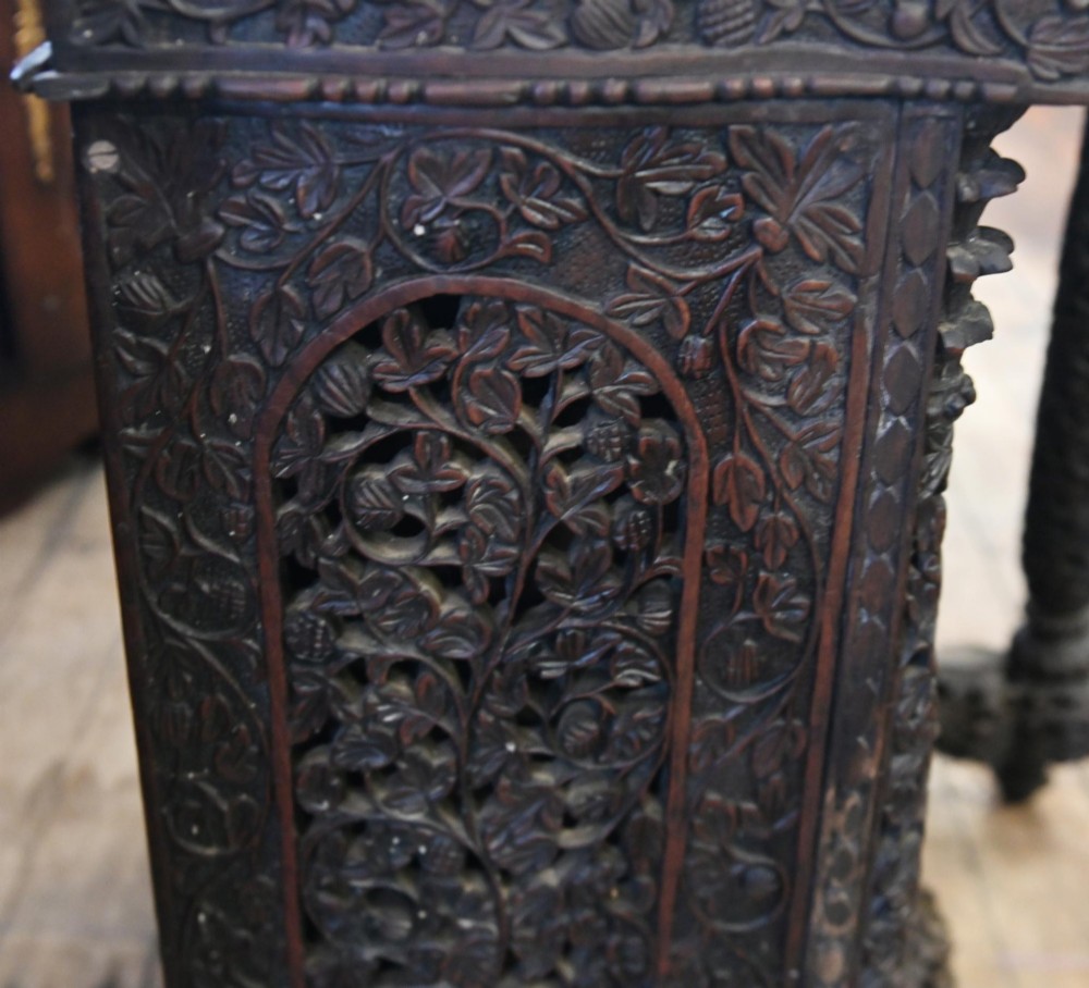 A dark hardwood Burmese Davenport desk with pierced carved floral decoration, an openwork gallery, and a terracotta leather writing surface. View II