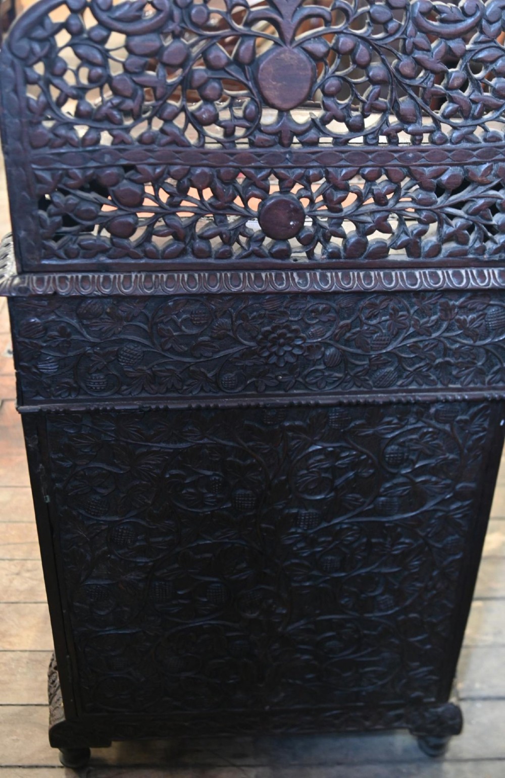 A dark hardwood Burmese Davenport desk with pierced carved floral decoration, an openwork gallery, and a terracotta leather writing surface. View IV