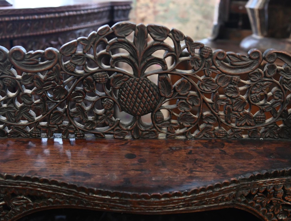 A dark hardwood Burmese Davenport desk with pierced carved floral decoration, an openwork gallery, and a terracotta leather writing surface. View V