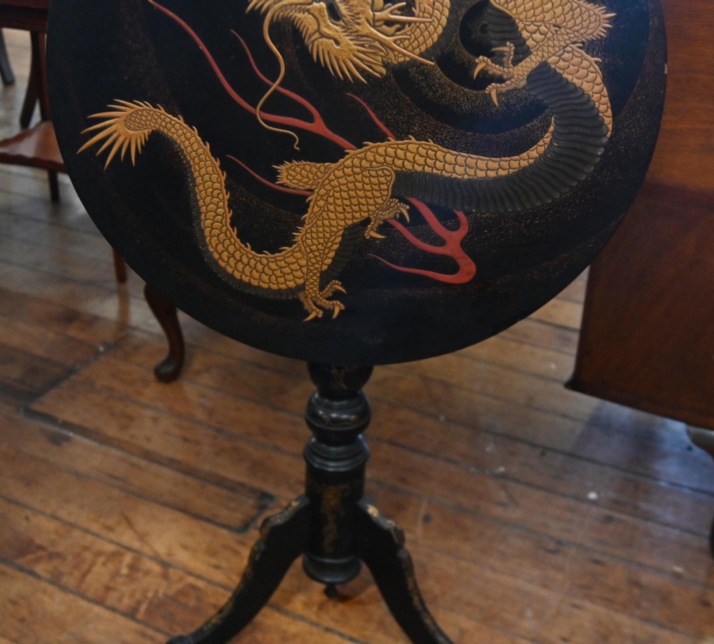 A black lacquered circular tilt-top side table featuring a gilt dragon motif, supported on a turned central column and tripod pedestal legs. View IV