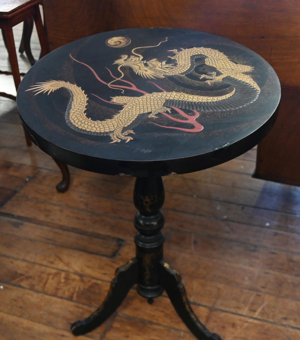 A black lacquered circular tilt-top side table featuring a gilt dragon motif, supported on a turned central column and tripod pedestal legs. View V