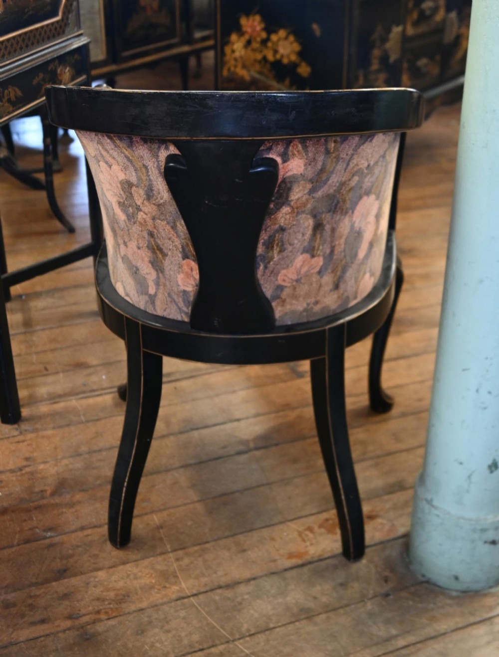 A pair of black lacquered Chinoiserie armchairs featuring hand-painted gold detail, curved backs, pink floral upholstery, and cabriole legs. View II