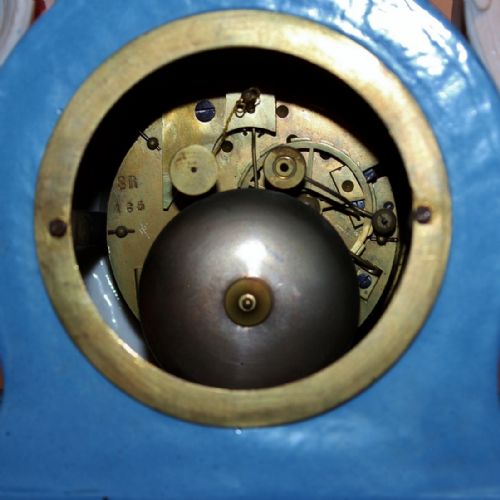 fig 3. An antique French Sevres-style porcelain mantel clock featuring cobalt blue glaze, hand-painted floral panels, gilt bronze mounts, and two sculpted cherub figures flanking the dial.