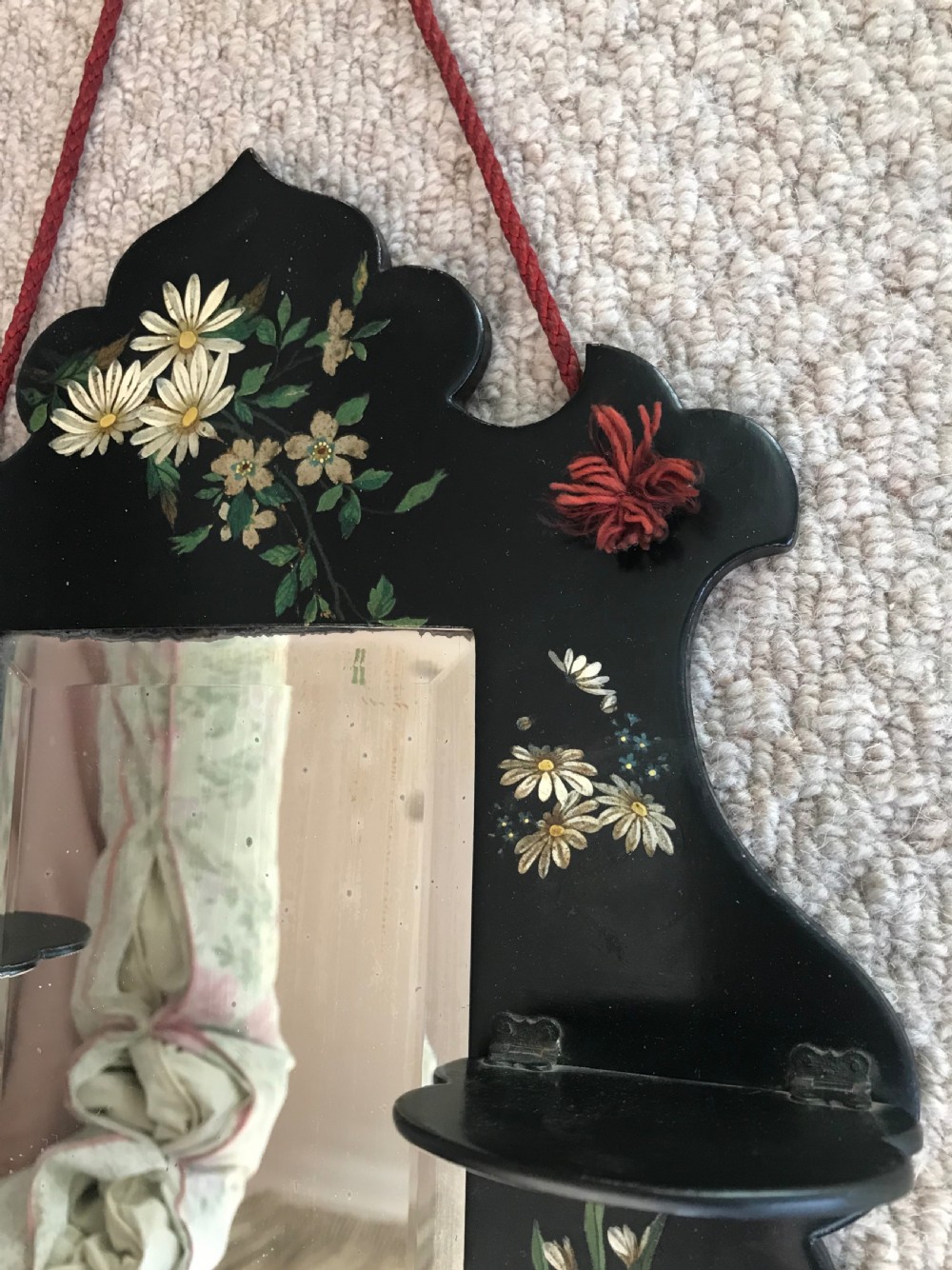 A Victorian ebonised wooden wall mirror featuring small tier display shelves and hand-painted white floral and bird motifs around a central rectangular mirror plate. View II