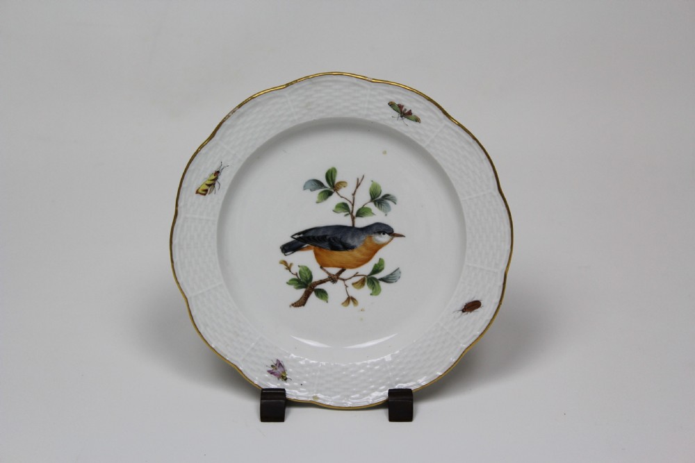 A set of three white circular porcelain plates featuring hand-painted birds perched on branches with small insect details, basketweave embossed borders, and gilded rims. View II