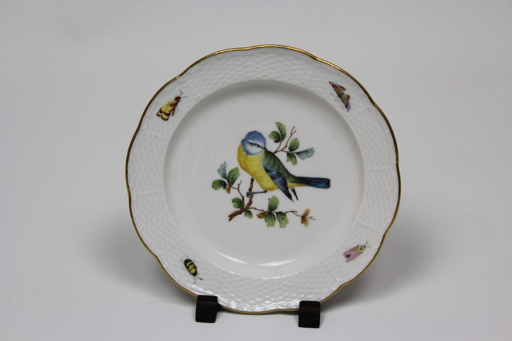 A set of three white circular porcelain plates featuring hand-painted birds perched on branches with small insect details, basketweave embossed borders, and gilded rims. View IV