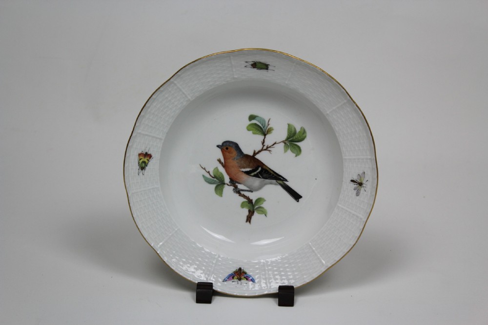 A set of three circular white porcelain dessert dishes featuring hand-painted birds and insects with basketweave moulded rims and gilt borders. View IV